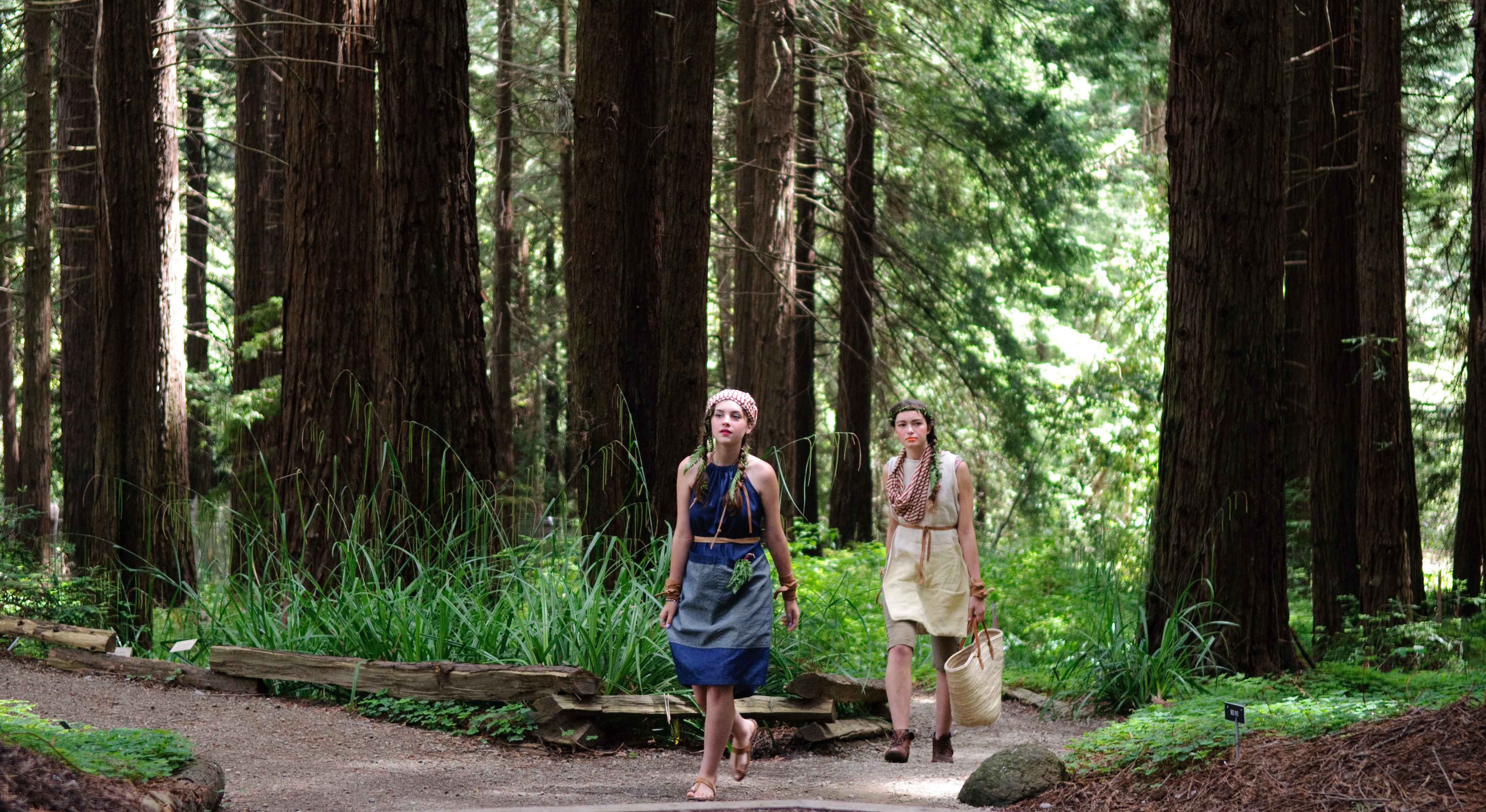Two models in nature-inspired outfits walking in the Redwood Grove