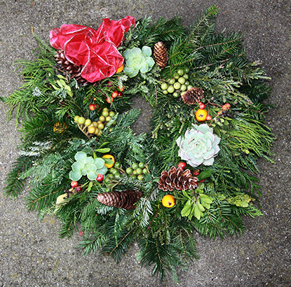 Holiday garden wreath with bow and succulents