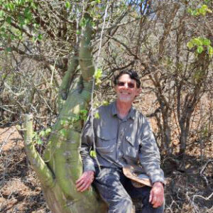 Photo of Fred Dortort lounging on enormous succulent plant in South Africa.