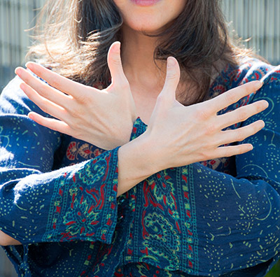 A woman has her hands crossed over her chest