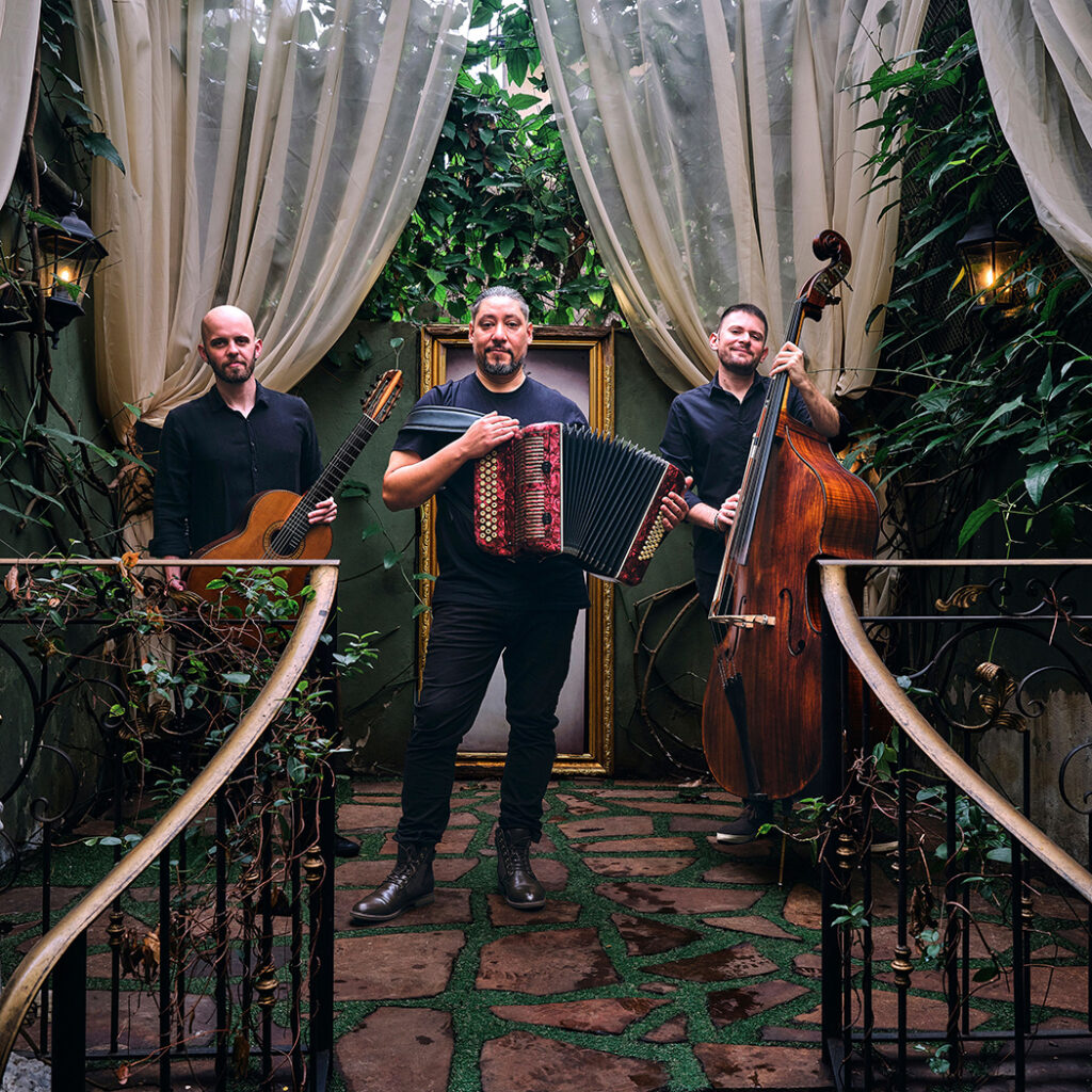 Three men standing holding musical instruments