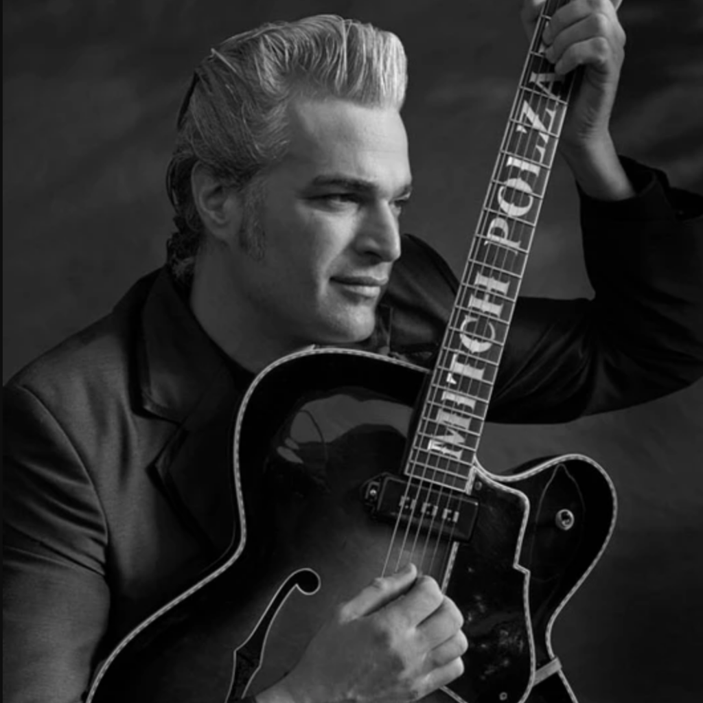 A black and white photo of a man holding a guitar