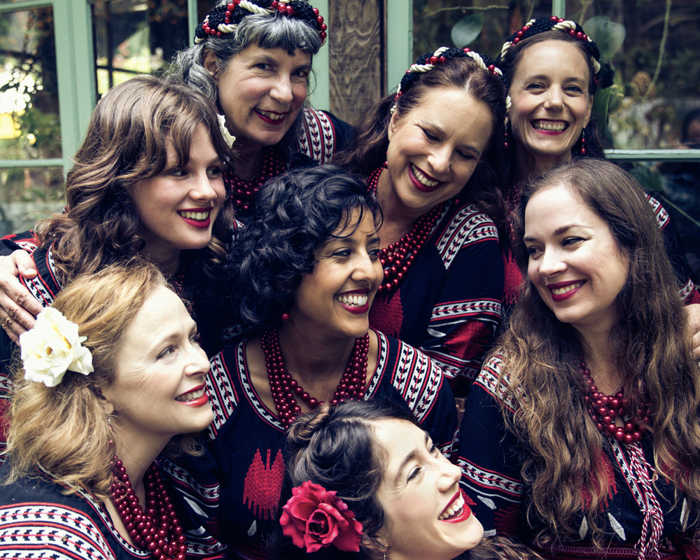 A group of smiling women in colorful costumes