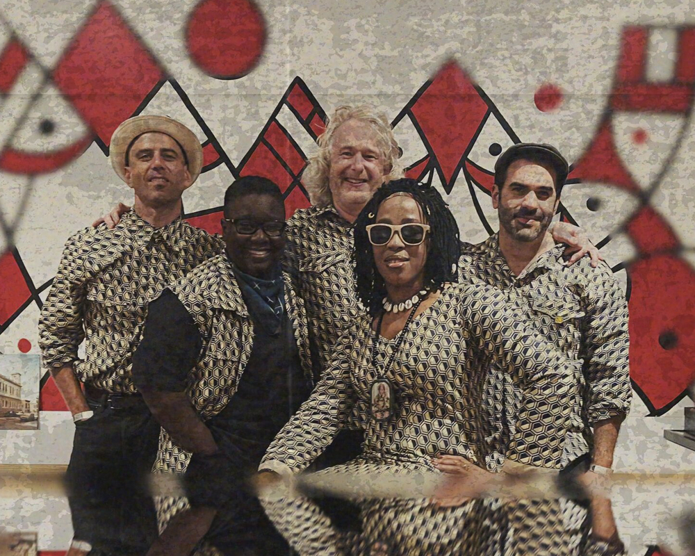 A group of adults smiling at the camera, wearing matching black and white outfits