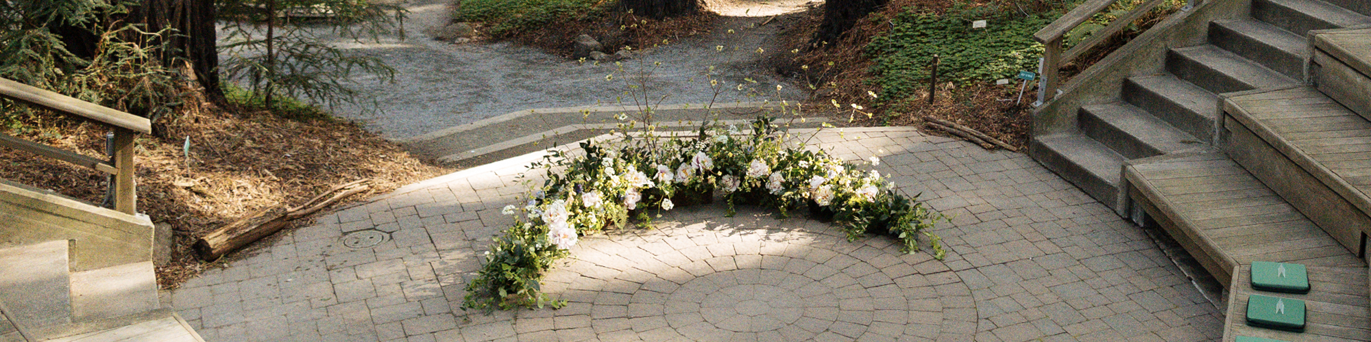 Sunlight shines on a wreath of flowers laid on a patio