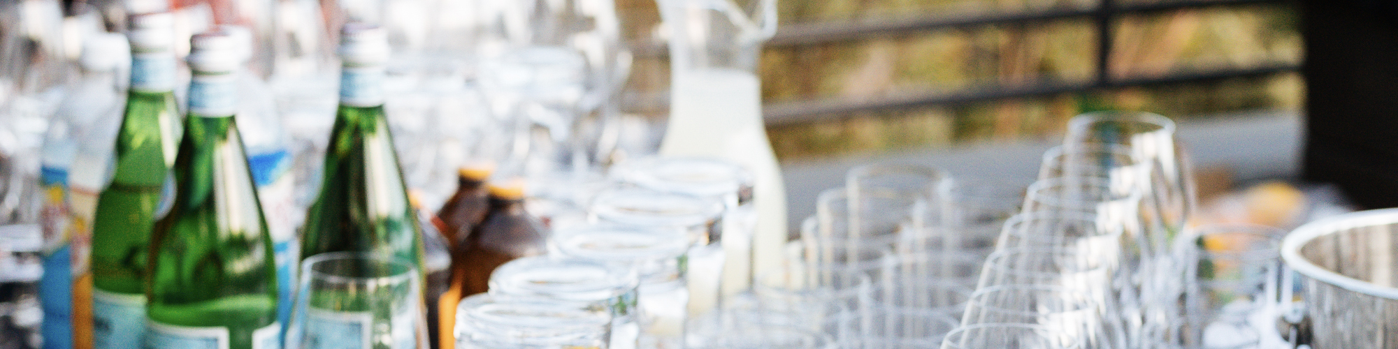 A table with many glasses and bottles of water for a party